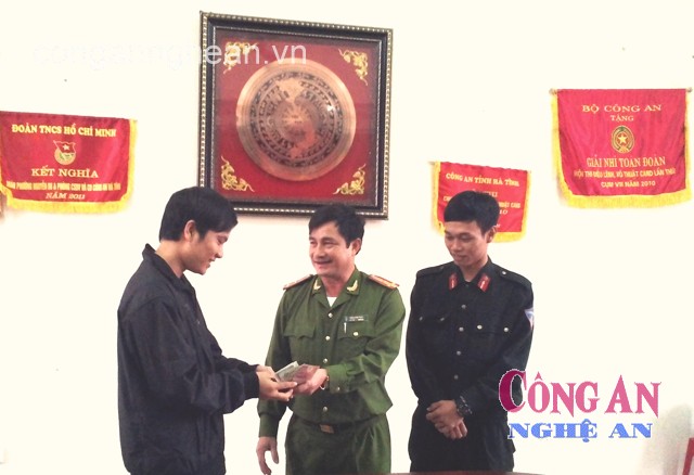 Thượng tá Trần Quốc Toản và đồng chí Phan Thanh Long trao lại tài sản cho người bị mất