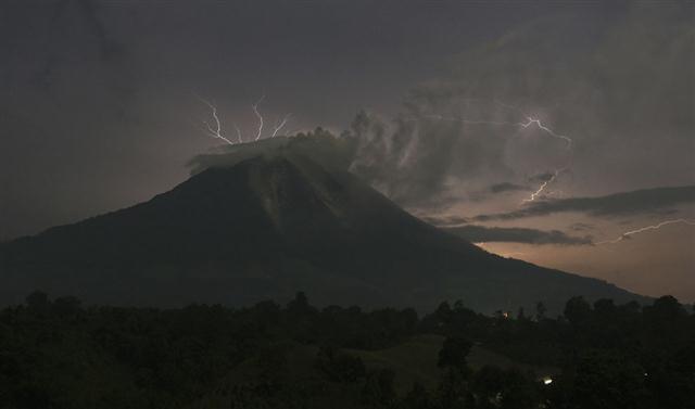 Những tia sét đánh xuống ngọn núi lửa Sinabung đang phun trào tro bụi và nham thạch nóng chảy ở làng Simpang Empat, quận Karo