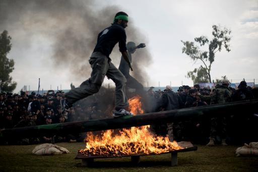 Một thanh niên Palestine nhảy qua chướng ngại vật trong một buổi lễ tốt nghiệp của một chương trình huấn luyện quân sự ở Gaza