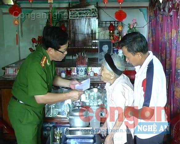 Đại tá Phan Huy Tải, Trưởng Công an huyện Đô Lương tặng quà cho mẹ Nguyễn Thị Huy, mẹ của 2 liệt sĩ