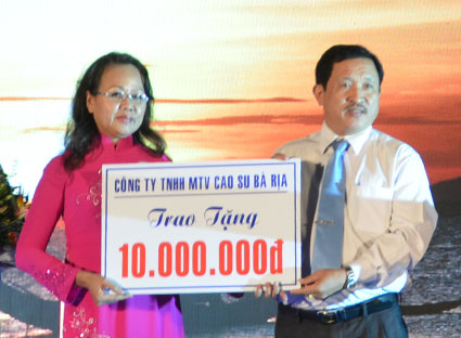 Bà Vương Thị Ngọc Yến, Chủ tịch Hội Chữ thập đỏ tỉnh nhận bảng tượng trưng ủng hộ đêm nhạc từ thiện từ đại diện Công ty TNHH MTV Cao su Bà Rịa.