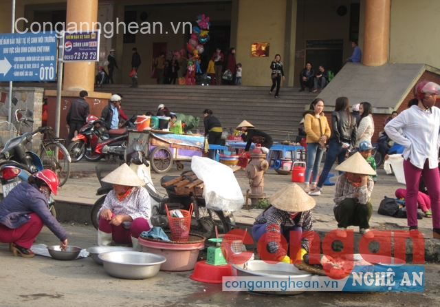 Tại cổng chợ Vinh, hàng thịt, cá được bày bán ngay dưới nền đất bẩn, ẩm ướt bên cạnh các chỗ ăn uống