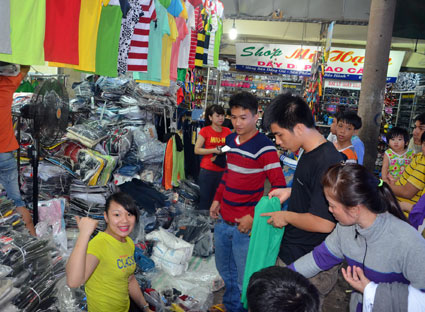 Các bạn trẻ mua áo thun, quần jeans made in Việt Nam tại sạp thời trang Thu, chợ Vũng Tàu.