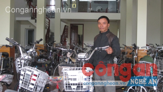 Anh Thìn bên cửa hàng xe đạp điện của gia đình