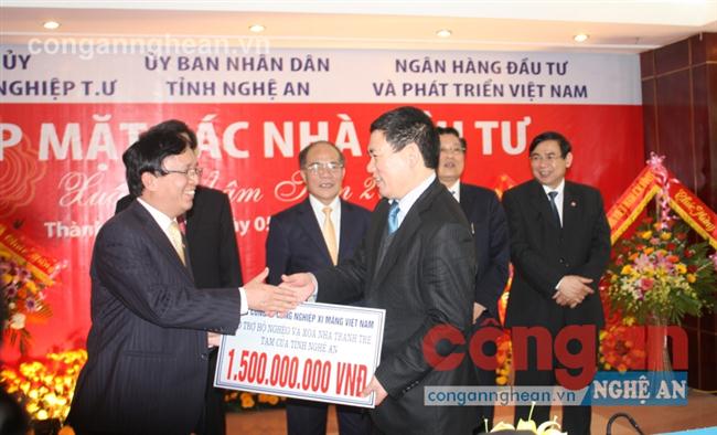 Cộng đồng doanh nghiệp đồng hành với công tác xã hội, xóa đói giảm nghèo trên địa bàn tỉnh (Trong ảnh: Đại diện các nhà đầu tư trao tiền hỗ trợ các xã nghèo tại Hội nghị xúc tiến đầu tư)