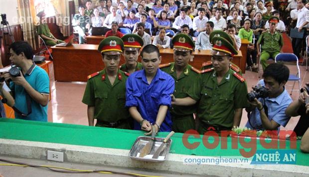 Bị cáo Vi Văn Hai đang nhận dạng hung khí gây án mà cơ quan điều tra thu được, tại tòa.