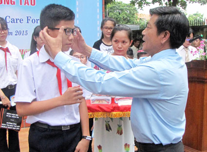Bác sĩ Nguyễn Văn Thái, Phó giám đốc Sở Y tế tặng kính cho HS nghèo.