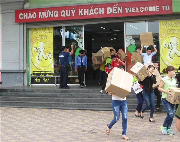 Cán bộ nhân viên trung tâm thương mại sơ tán hàng hóa ra khỏi khu vực cháy