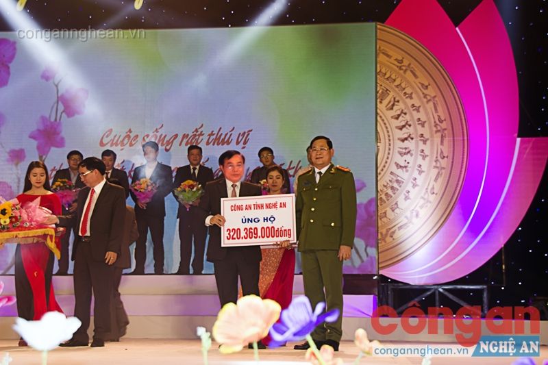 Đồng chí Đại tá Nguyễn Hữu Cầu, Ủy viên BTV Tỉnh ủy, Bí thư Đảng ủy, Giám đốc Công an Nghệ An trao số tiền ủng hộ người nghèo đón Tết