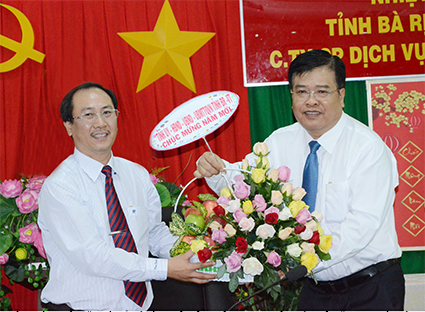 Đồng chí Nguyễn Văn Trình, Phó Bí thư Tỉnh ủy, Chủ tịch UBND tỉnh (bên phải) tặng hoa chúc mừng năm mới Công ty Cổ phần Dịch vụ Môi trường và Công trình Đô thị Vũng Tàu. Ảnh: THÀNH HUY