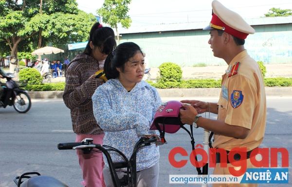CBCS Đội CSGT Công an TP Vinh nhắc nhở học sinh, sinh viên về việc đội mũ bảo hiểm khi đi xe đạp điện