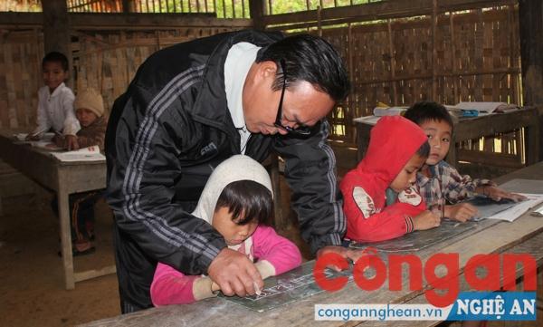 Thầy Lan dạy chữ cho các em học sinh lớp 1