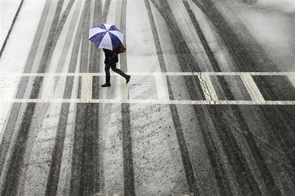 Một người khách bộ hành băng ngang đường ở Boston trong một trận bão tuyết.