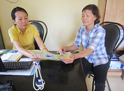 Nhân viên đại lý thu BHYT xã Xuyên Mộc, huyện Xuyên Mộc (bên trái) tuyên truyền về lợi ích của BHYT cho người dân.