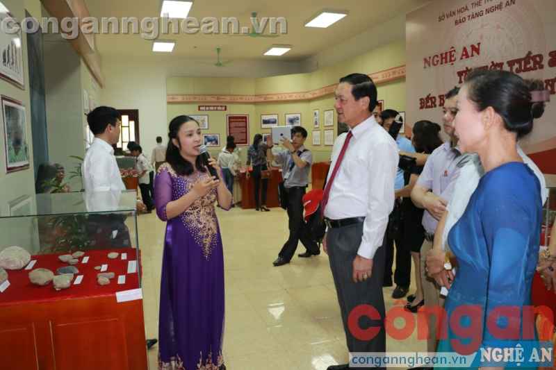 Đồng chí Lê Minh Thông và các đại biểu nghe giới thiệu về các gian trưng bày, triển lãm