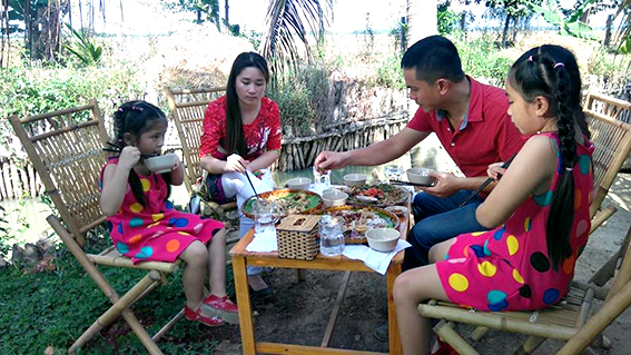 Một gia đình du khách dùng bữa trong khung cảnh đồng quê ở KDL Tứ Phương Thất Đảo.