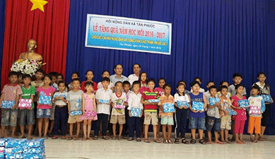 Đại diện Hội Nông dân xã Tân Phước trao quà cho học sinh nghèo.