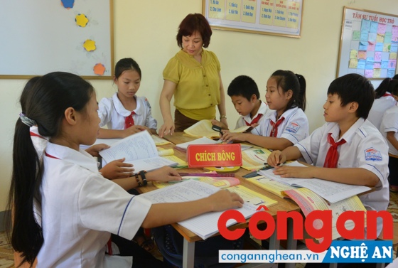 Để đạt chuẩn chức danh nghề nghiệp, giáo viên phải đáp ứng trình độ Ngoại ngữ, Tin học, tham gia thi xét thăng hạng (Trong ảnh: Cô và trò trường THCS Lê Lợi, TP Vinh trong giờ học)