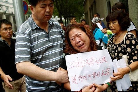 Thân nhân một hành khách đi trên chuyến bay Malaysia MH370 mất tích cách đây 2 năm biểu tình trước trụ sở Bộ ngoại giao Trung Quốc ở Bắc Kinh hôm 29-7 đòi câu trả lời từ chính phủ về số phận người thân của họ - Ảnh: Reuters