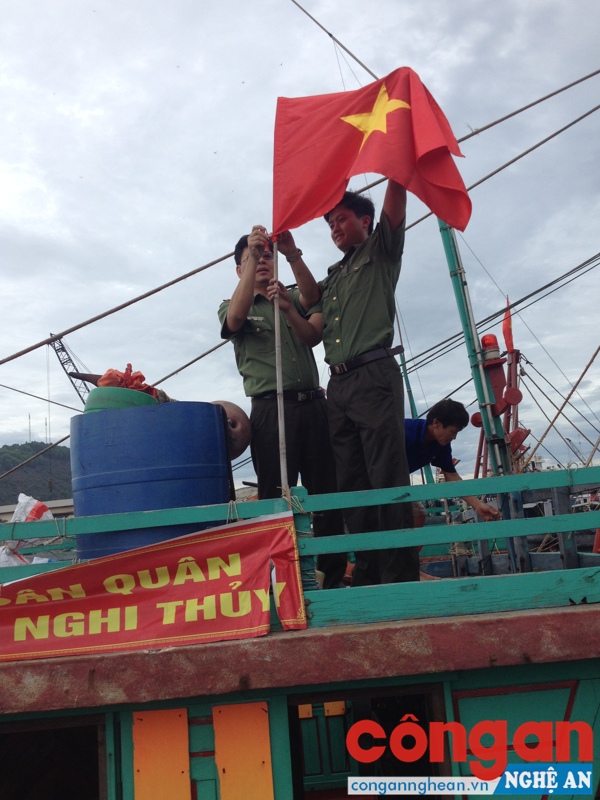 Giúp bà con ngư dân cắm cờ tổ quốc trên thuyền