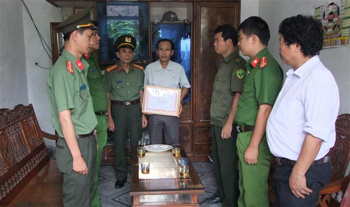 Thừa ủy quyền Giám đốc Công an tỉnh, Thượng tá Nguyễn Thọ Nhung, Phó trưởng phòng Xây dựng phong trào toàn dân bảo vệ ANTQ tặng Giấy khen và quà cho đồng chí Thái Phúc Hạnh