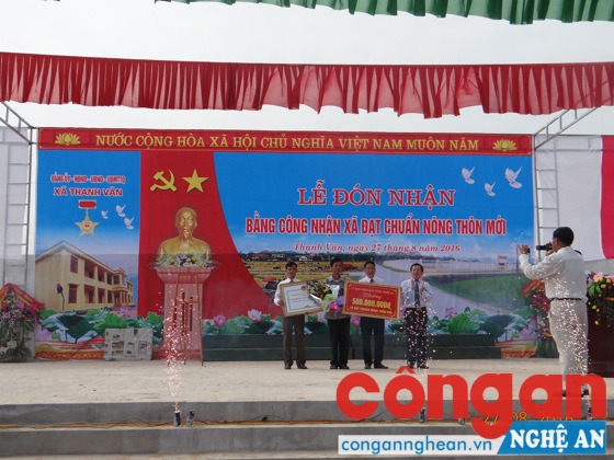 Đồng chí Đinh Viết Hồng, Phó Chủ tịch UBND tỉnh trao bằng công nhận xã đạt chuẩn NTM cho lãnh đạo xã Thanh Văn  