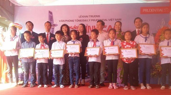 Đại diện công ty Prudential và các địa biểu trao qùa cho học sinh nghèo