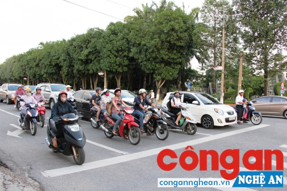Người tham gia giao thông dừng xe chờ tín hiệu đèn giao thông trên đường Trường Thi, TP Vinh