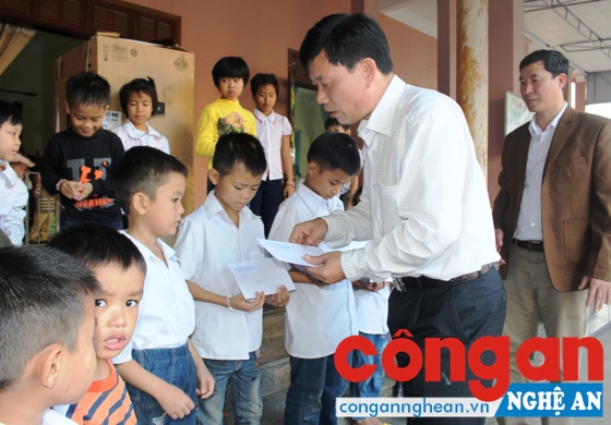 Đại tá Lê Văn Thái, Trưởng Công an huyện Hưng Nguyên tặng quà cho các em học sinh mồ côi, có hoàn cảnh khó khăn của dòng tu Mến Thánh Giá Trang Nứa, xã Hưng Yên Bắc