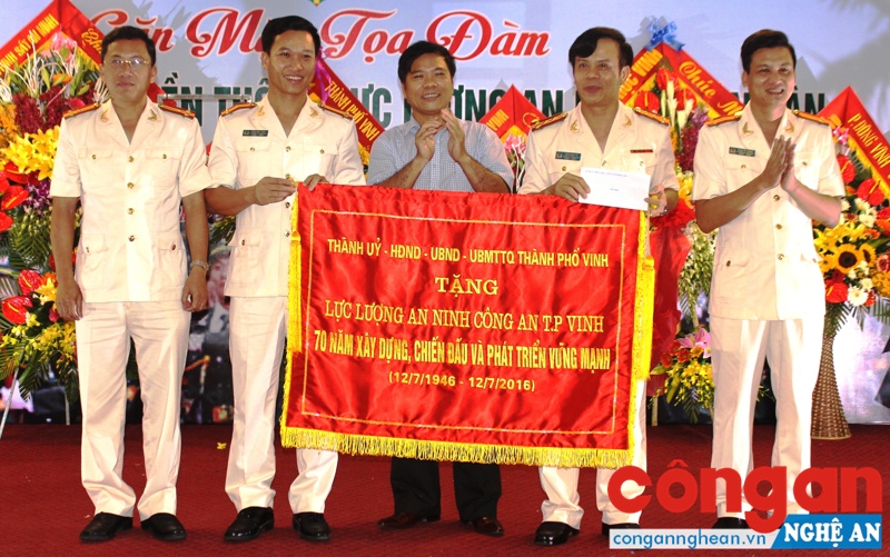 Đồng chí Nguyễn Hoài An, Phó Bí thư Thành ủy, Chủ tịch UBND TP Vinh trao bức trướng cho Công an TP Vinh nhân dịp kỷ niệm 70 năm Ngày truyền thống lực lượng ANND (12/7/1946 - 12/7/2016)