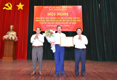 Đồng chí Nguyễn Văn Xinh, Ủy viên Ban Thường vụ Tỉnh ủy, Trưởng Ban Tuyên giáo Tỉnh ủy, Trưởng Ban Tổ chức cuộc thi và đồng chí Trần Văn Thông, Tỉnh ủy viên, Phó Trưởng Ban Tuyên giáo Tỉnh ủy, Phó Ban Tổ chức cuộc thi tặng giấy khen và hoa cảm ơn NSƯT Nguyễn Văn Tân – Người thể hiện hình tượng Bác Hồ tại hội nghị.