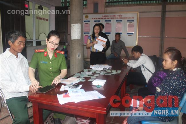 Cán bộ làm nhiệm vụ tại “Bộ phận một cửa” Công an tỉnh vừa trực tiếp trả CMND  và tranh thủ làm thủ tục cấp CMND cho người dân