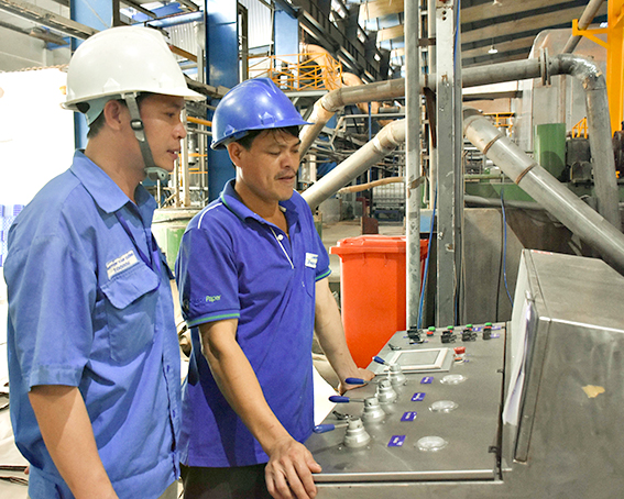 Anh Nguyễn Văn Cường (bìa trái), Phó Quản đốc bộ phận sản xuất Công ty CP Giấy Sài Gòn (KCN Mỹ Xuân A2, huyện Tân Thành) trao đổi công việc với công nhân tại bộ phận sản xuất của công ty.