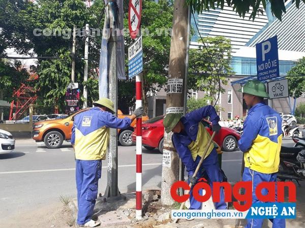 Công nhân tháo dỡ biển báo cũ để thay mới