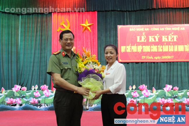 Đồng chí Phạm Thị Hồng Toan - Tổng biên tập Báo Nghệ An tặng hoa chúc mừng Nhân Ngày thành lập lực lượng CAND cho đồng chí Đại tá Nguyễn Hữu Cầu - Giám đốc Công an tỉnh