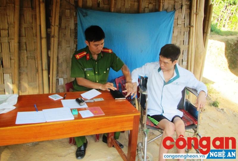 Cán bộ Đội Cảnh sát QLHC về TTXH Công an huyện Tương Dương đến tận nhà làm thủ tục cấp CMND cho người tàn tật tại bản Sàn, xã Hữu Khuông