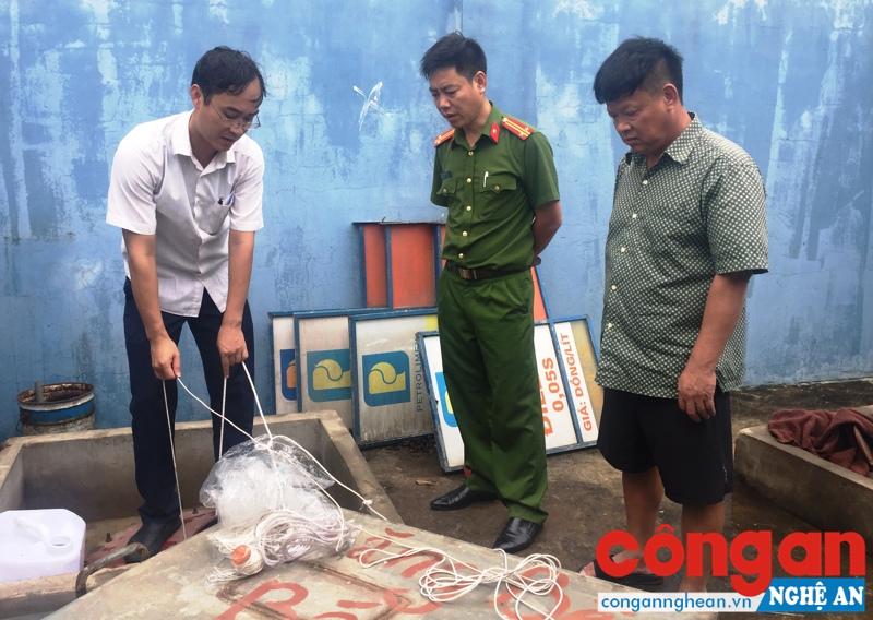 Chủ doanh nghiệp Thanh Ngũ (bên phải) và lực lượng Cảnh sát Kinh tế kiểm tra bồn chứa xăng, lấy mẫu để giám định phục vụ công tác điều tra