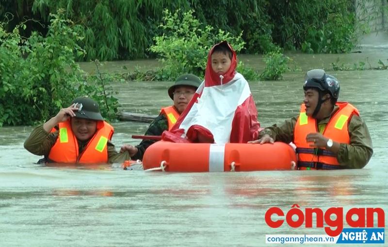 Lực lượng Công an ngâm mình trong nước sơ tán người dân ra khỏi vùng bị ngập nặng -  Ảnh: Xuân Bắc