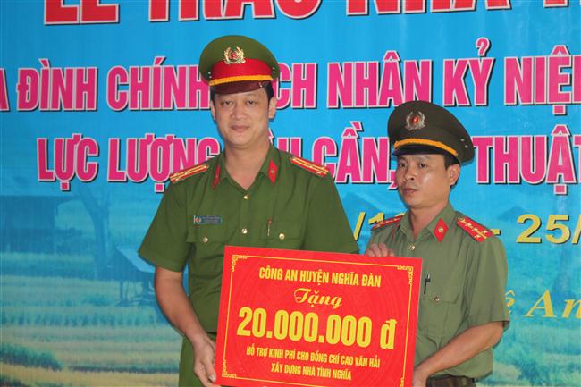 Thượng tá Nguyễn Đức Cường - Trưởng Công an huyện Nghĩa Đàn trao quà cho đồng chí Ca Văn Hải