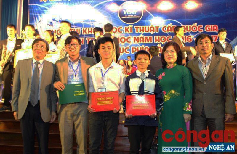 Thầy giáo Nguyễn Đình Hòa (đứng thứ 2 từ trái qua) chụp ảnh lưu niệm với 2 học sinh Ngô Thành Đạt và Nguyễn Tiến Dũng cùng dự án “Khai thác nước ngọt cho người dân vùng biển dùng năng lượng mặt trời” (đạt giải Khuyến khích cấp Quốc gia cuộc thi Sáng tạo khoa học năm 2016 - 2017)