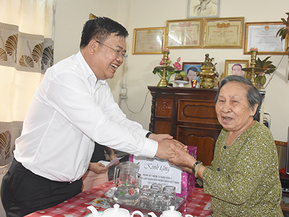 Đồng chí Nguyễn Văn Trình, Chủ tịch UBND tỉnh ân cần thăm hỏi và tặng quà bà Võ Thị Thanh (83 tuổi) ở khu dân cư số 7, vợ liệt sĩ Lê Nhiên.