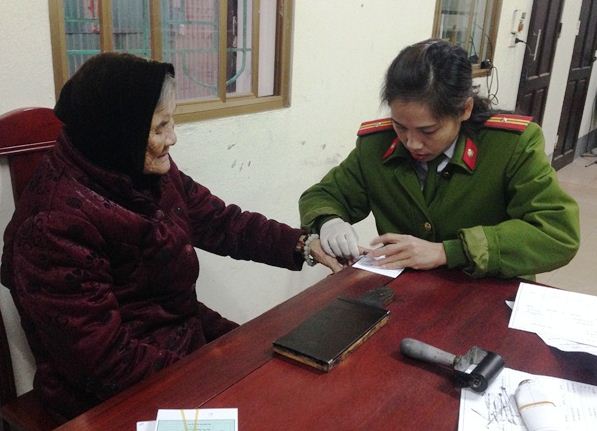 Thiếu tá Vi Thị Bình, cán bộ Phòng Cảnh sát QLHC về TTXH Công an tỉnh làm thủ tục cấp CMND cho cụ Quế Thị Lĩnh (91 tuổi) trú tại xã Diễn Phong, huyện Diễn Châu