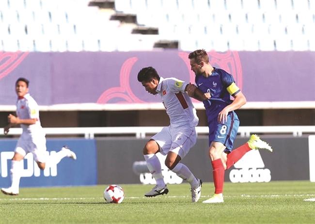 Cầu thủ U.20 Việt Nam (trái) đấu U.20 Pháp tại VCK World Cup U.20 thế giới - một trong những khoảnh khắc đẹp nhất trong năm cũ.