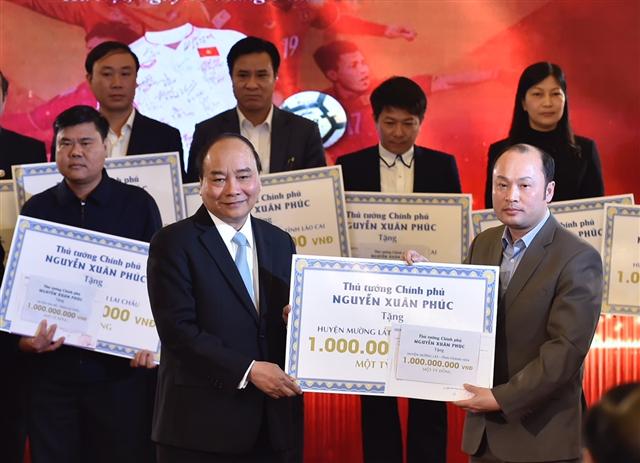 Thủ tướng trao kinh phí từ đấu giá bóng, áo của đội U23 cho 20 huyện nghèo. Ảnh: VGP/Nhật Bắc