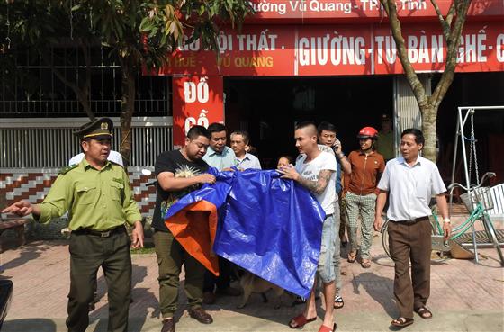 anh Hướng (người mặc áo đen bên trái) cùng người dân bàn giao con rùa cho lực lượng Kiểm lâm.