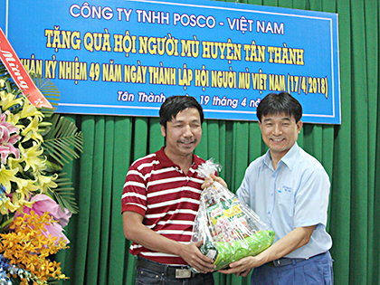 Ông Nam Sung Kon, Phó Tổng Giám đốc Công ty Posco Việt Nam (bìa phải) trao quà cho hội viên Hội Người mù huyện Tân Thành.