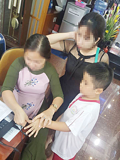 Nhân viên tư vấn sinh trắc vân tay tại TP.Vũng Tàu tiến hành scan dấu vân tay của trẻ em. 