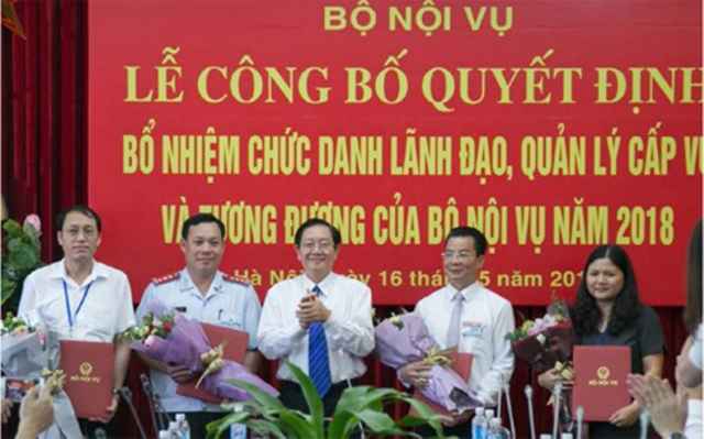 Bộ trưởng Bộ Nội vụ Lê Vĩnh Tân trao các Quyết định bổ nhiệm cho 4 cán bộ trúng tuyển sau đợt thi tuyển chức danh quản lý cấp vụ và tương đương năm 2018 (Ảnh: xaydungdang.org.vn)