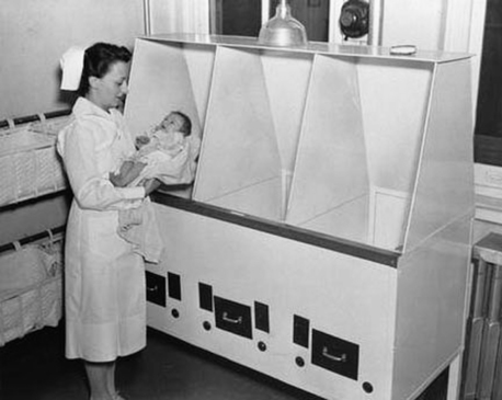 Y tá bế một trẻ sinh non gần lồng ấp tại một bệnh viện năm 1940. 