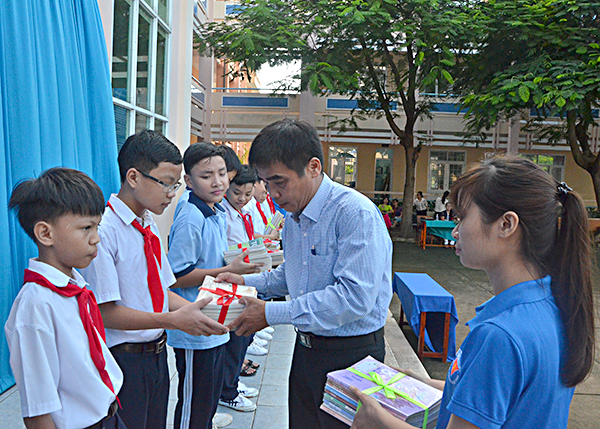 Ông Huỳnh Tới, Phó Giám đốc Thư viện tỉnh tặng SGK cho HS nghèo của trường.